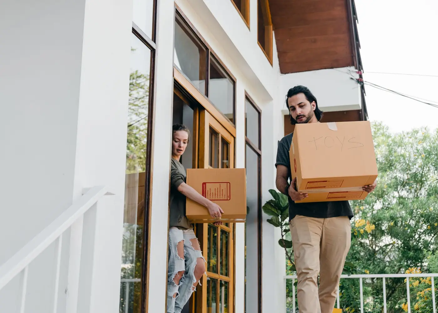 Couple carrying boxes during a house move